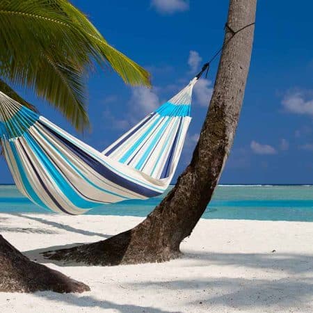 La Siesta Caribeña Aqua Blue, singelhängmatta i blå-vit som hänger mellan två palmträd vid havet